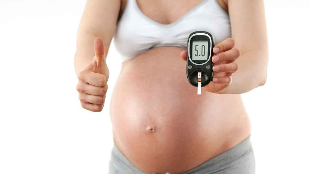 pregnant woman showing excellent glucose levels on her monitor