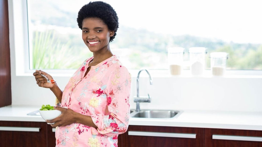 happy pregnant woman eating a salad