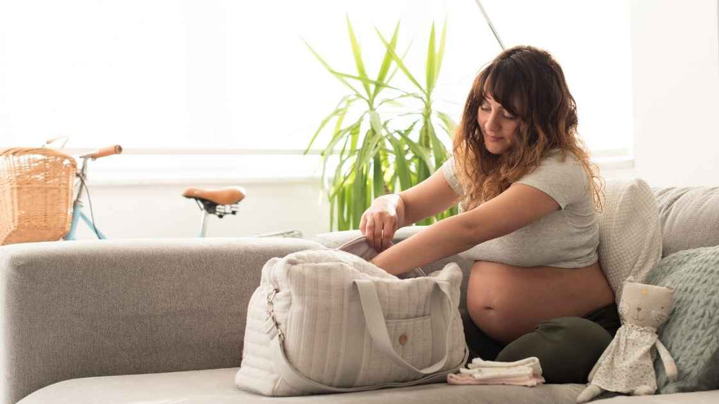 pregnant woman finishing the packing of her hospital bag