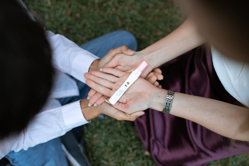 two women looking at a pregnancy test wand