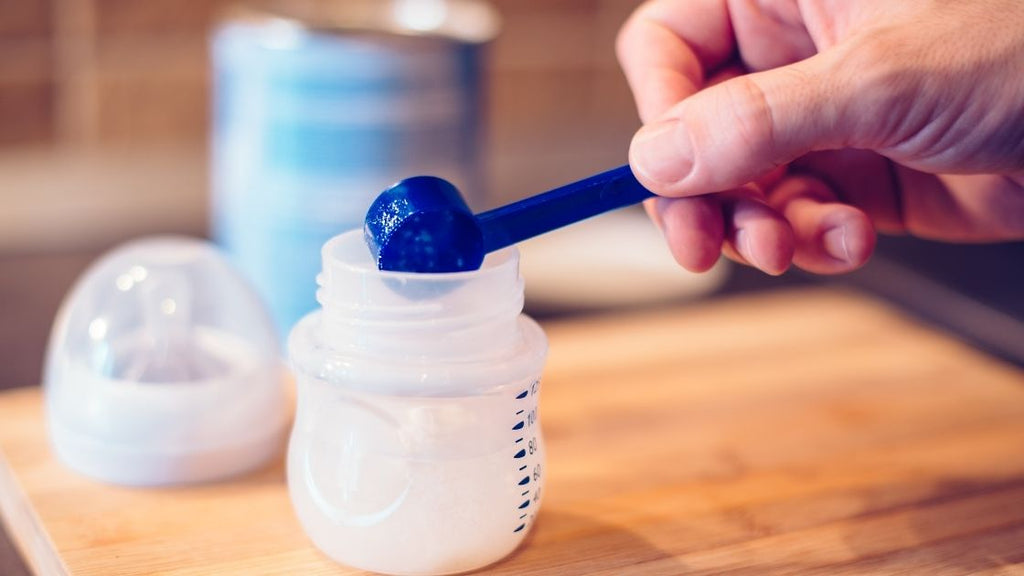 hand mixing infant formula in baby bottle