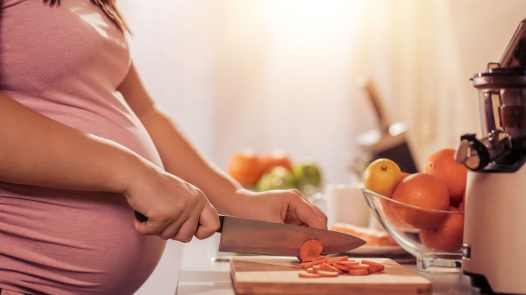 pregnant woman cutting up carrots