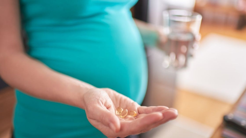 pregnant woman holding prenatal supplements