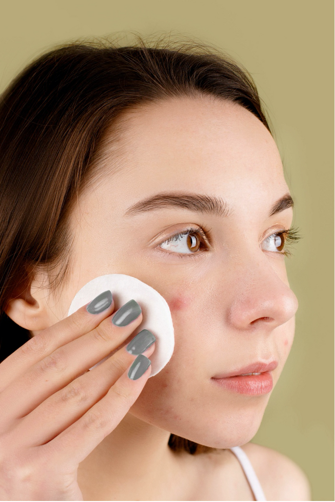 woman using cotton pad with facial cleanser or toner