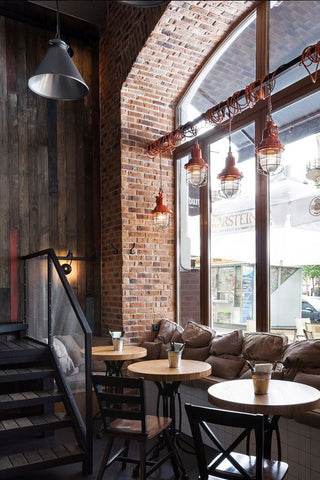Elements such as wood textures, warm brick walls, industrial lights and concrete facades create a beautiful, honest backdrop for a modern restaurant interior. 