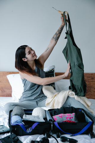 women packing suitcase with nice clothes