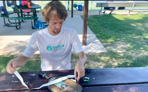 Hugh Davis eco of revolin sports putting overgrip on a Pickleball paddle in Ludington michigan