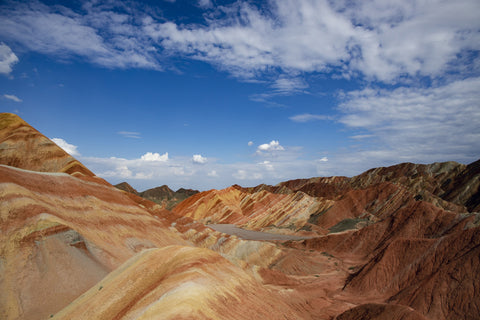 Bright blue sky above red sandstone cliffs and formations in Zhangye National Geopark in China