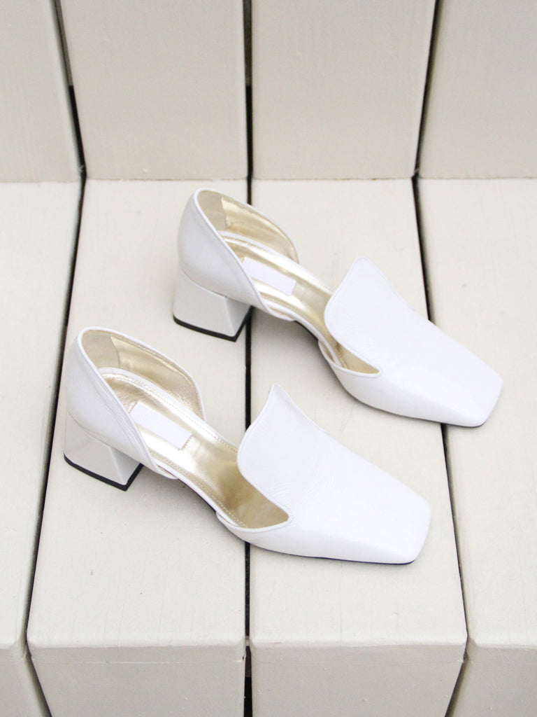 White patent leather square-toe loafer with d'orsay sides and boxy, structural heel. by Susanne Rae