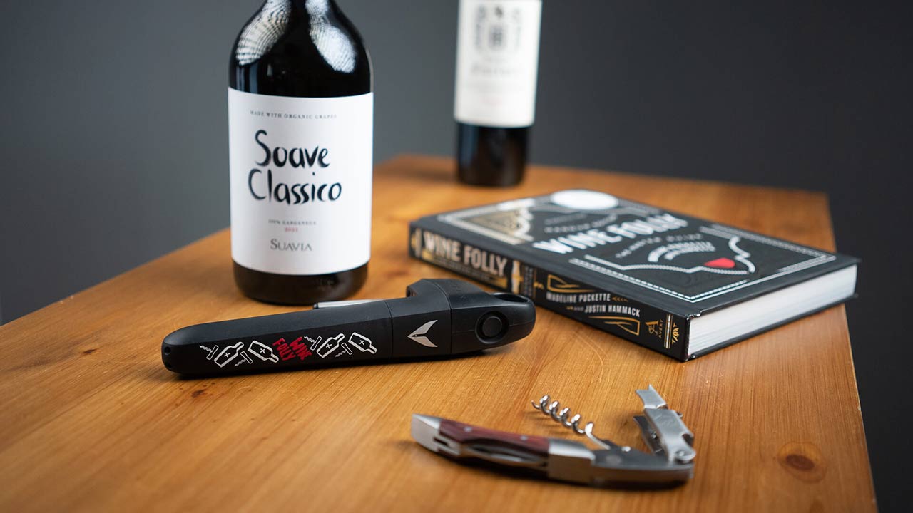 Coravin Pivot (Wine Folly Art Edition) on a table with a wine book and a bottle of Sauvia Soave Classico