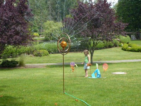 child playing in sprinkler