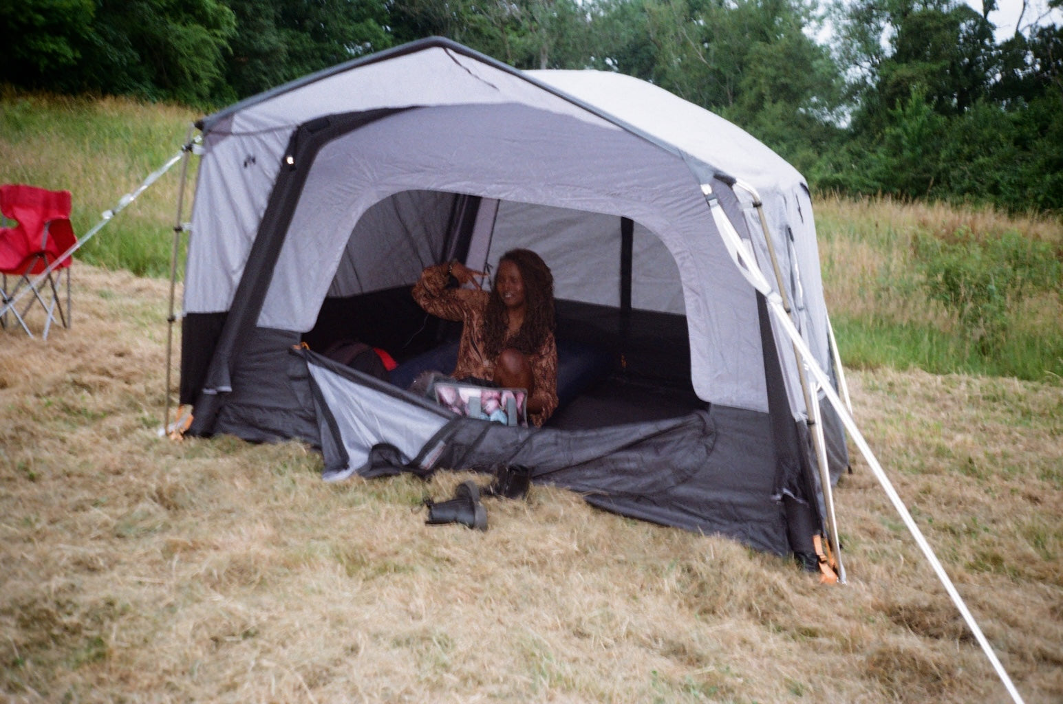 A woman sitting in a grey tent with the door open
