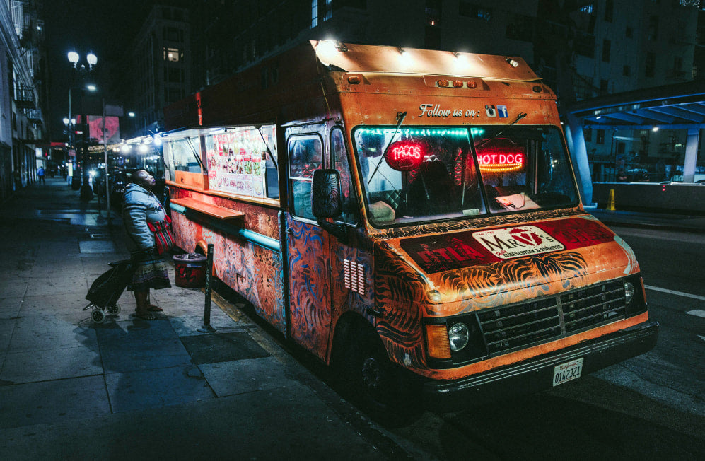 Food wagon illuminated at night on the side of a road in california.