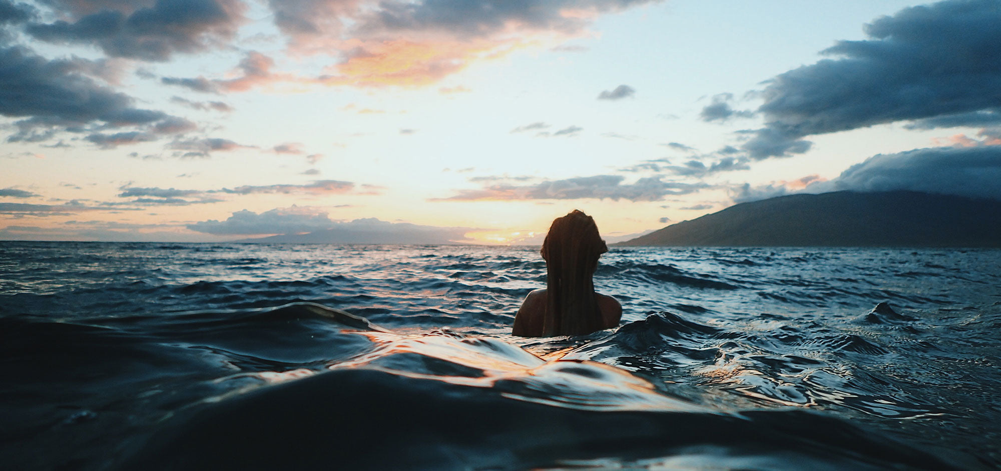 Woman takes a cold dip in the ocean.