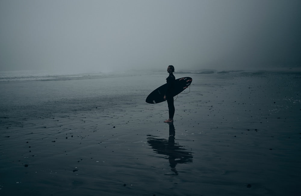 Sense of adventure: A surfer stands on the shoreline looking out to see, getting ready to enter the water.