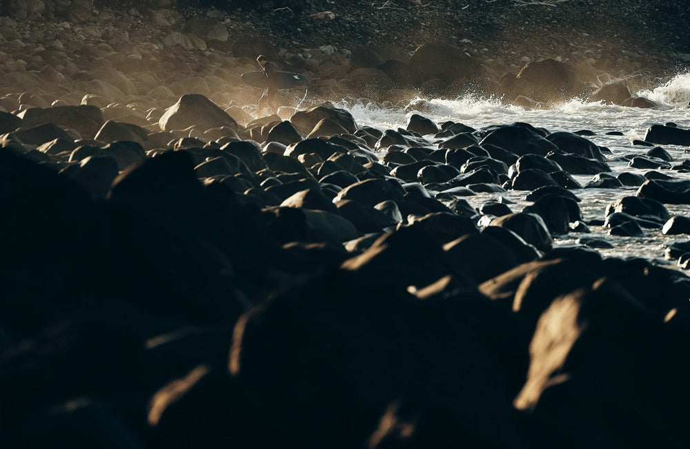 Sense of adventure: Water and sea mist roll over boulders on the shoreline