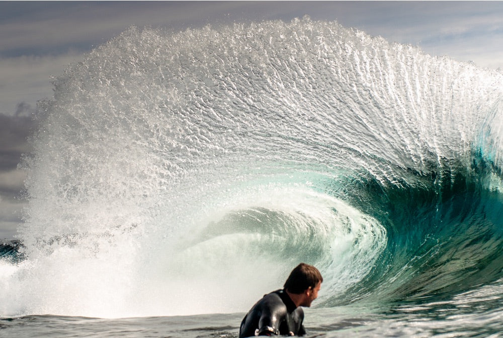 A bodyboarder sits deep in a barelling wave