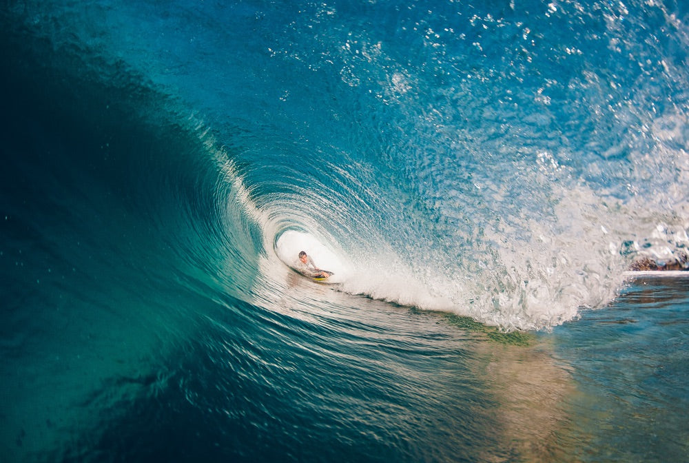 A bodyboarder sits deep in a barelling wave