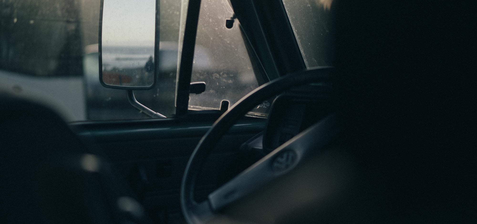 Looking out the window of a classic VW Westy towards waves rolling in.