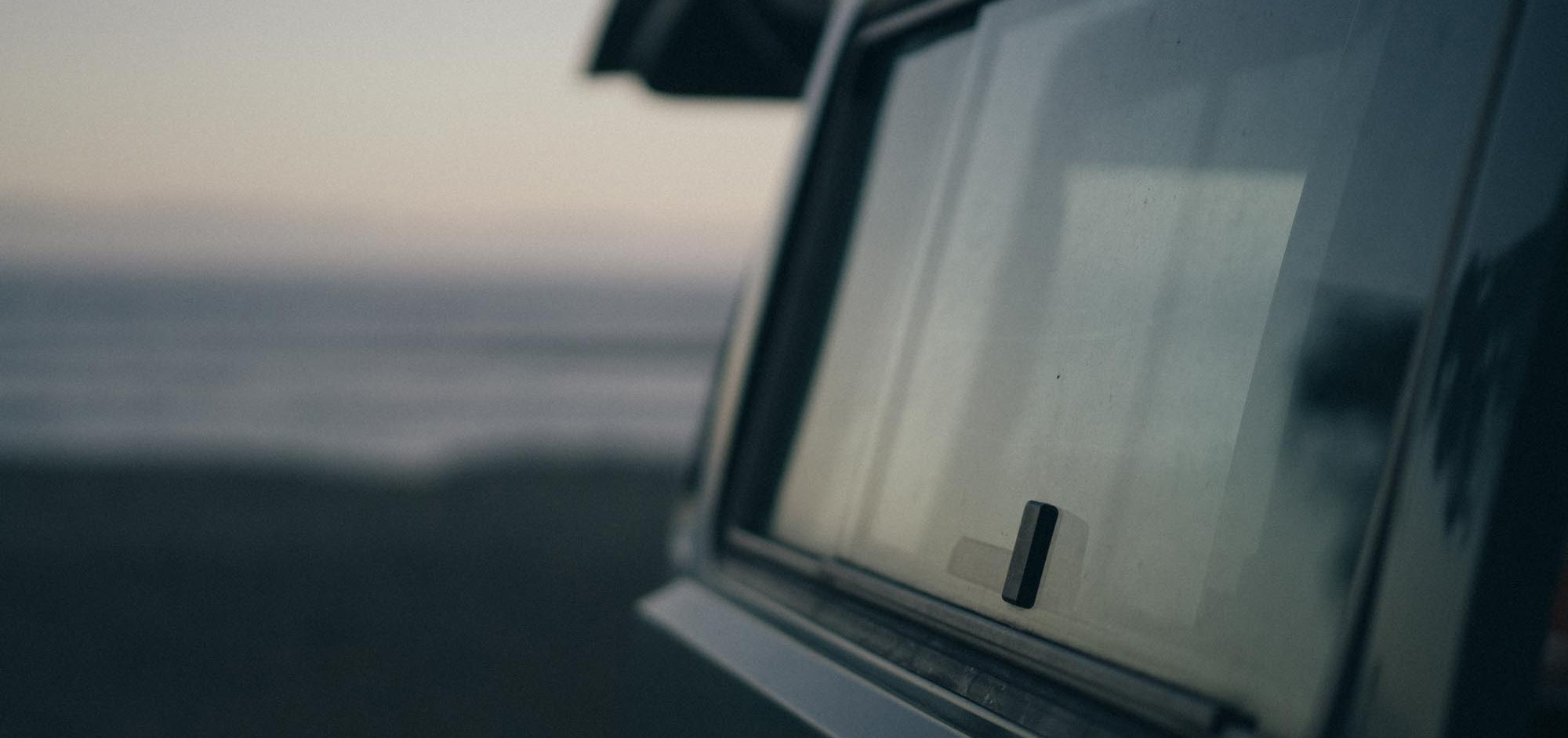 A dusky blue-hour sky reflects off the rear window of a classic VW Westy campervan