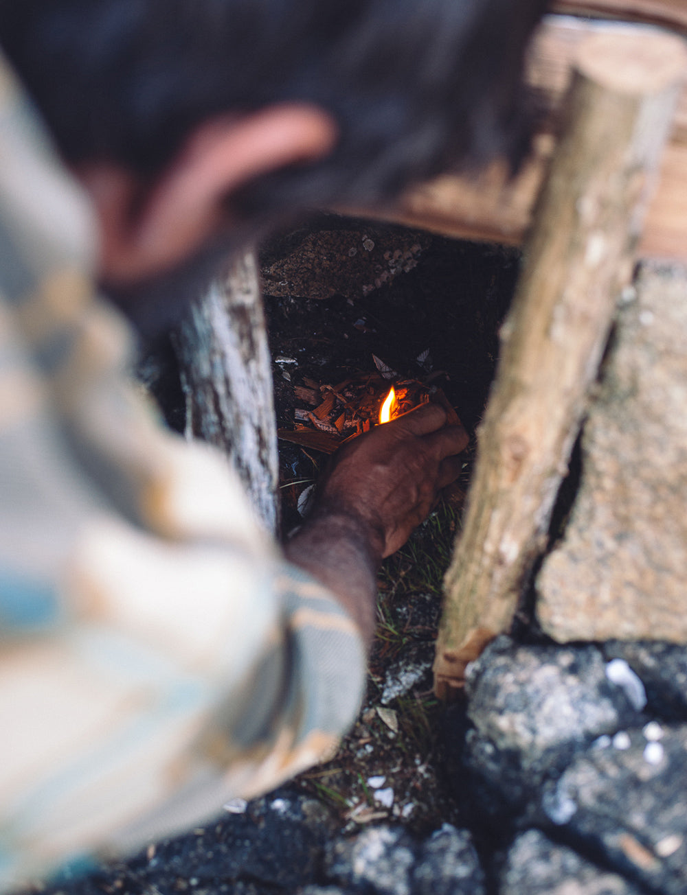 Ein Mann kümmert sich um ein kleines Feuer in einem Schornstein