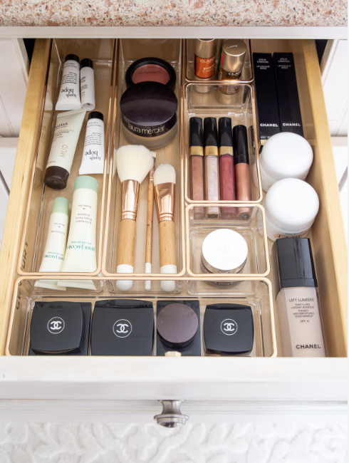 A make up drawer organized with clear bins,