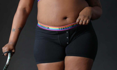 Person with walking aid wearing black boxers with rainbow band