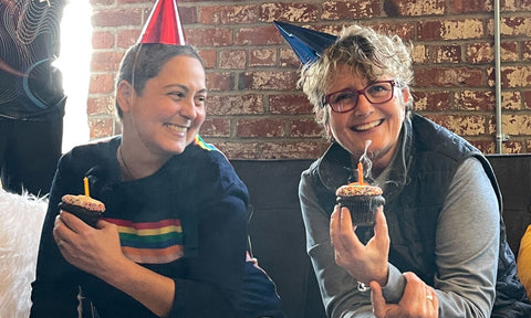 Fran and Naomi Anniversary photo with party hats and cupcakes