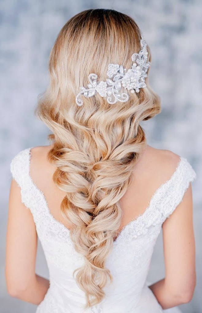 Long and loose braided hairstyle for a luxuriously romantic bridal look.