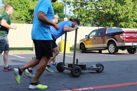 crossfit athletes push sled