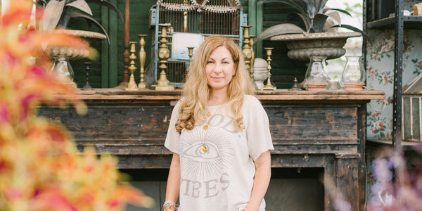 Image of artist with antiques in the background and fall colored foliage in the foreground.