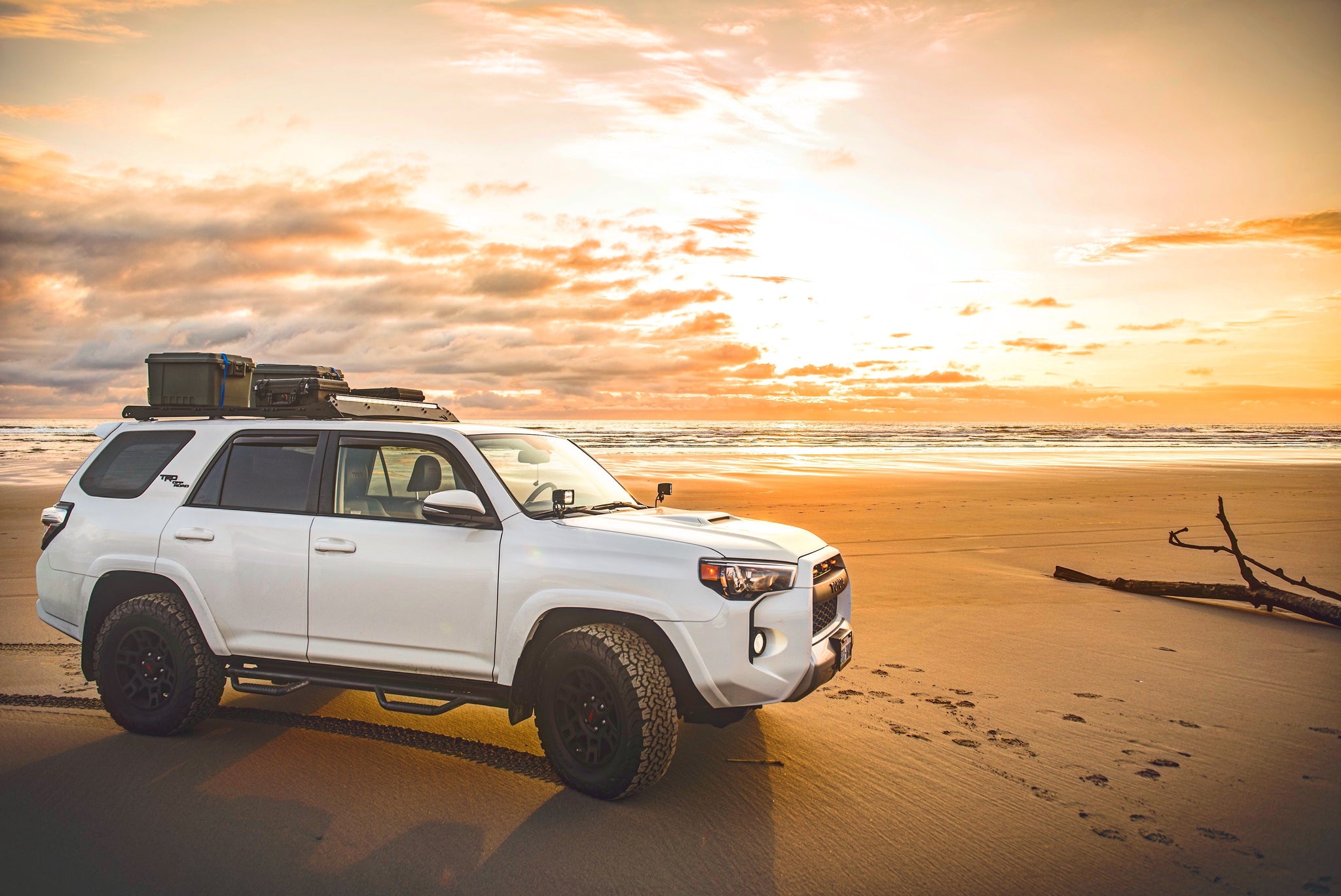 Overlanding truck driving through a desert landscape.