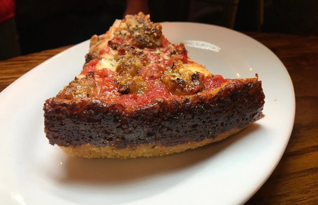 Slice of chicago style deep dish pizza on a white plate from Labriola