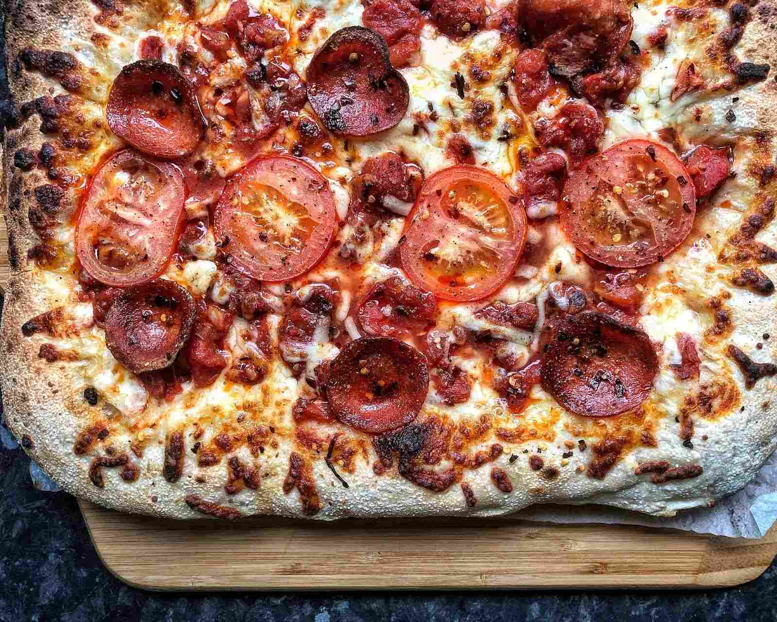 Grandma pizza with tomatoes, pepperoni, and mozzarella.