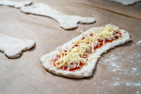 Skeleton hips as a pizza covered in tomato sauce and cheese