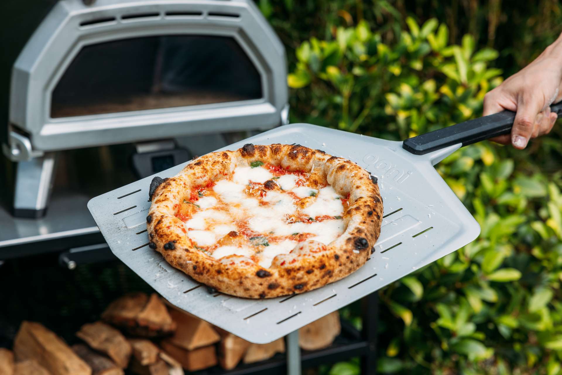 margherita pizza on a perforated pizza peel