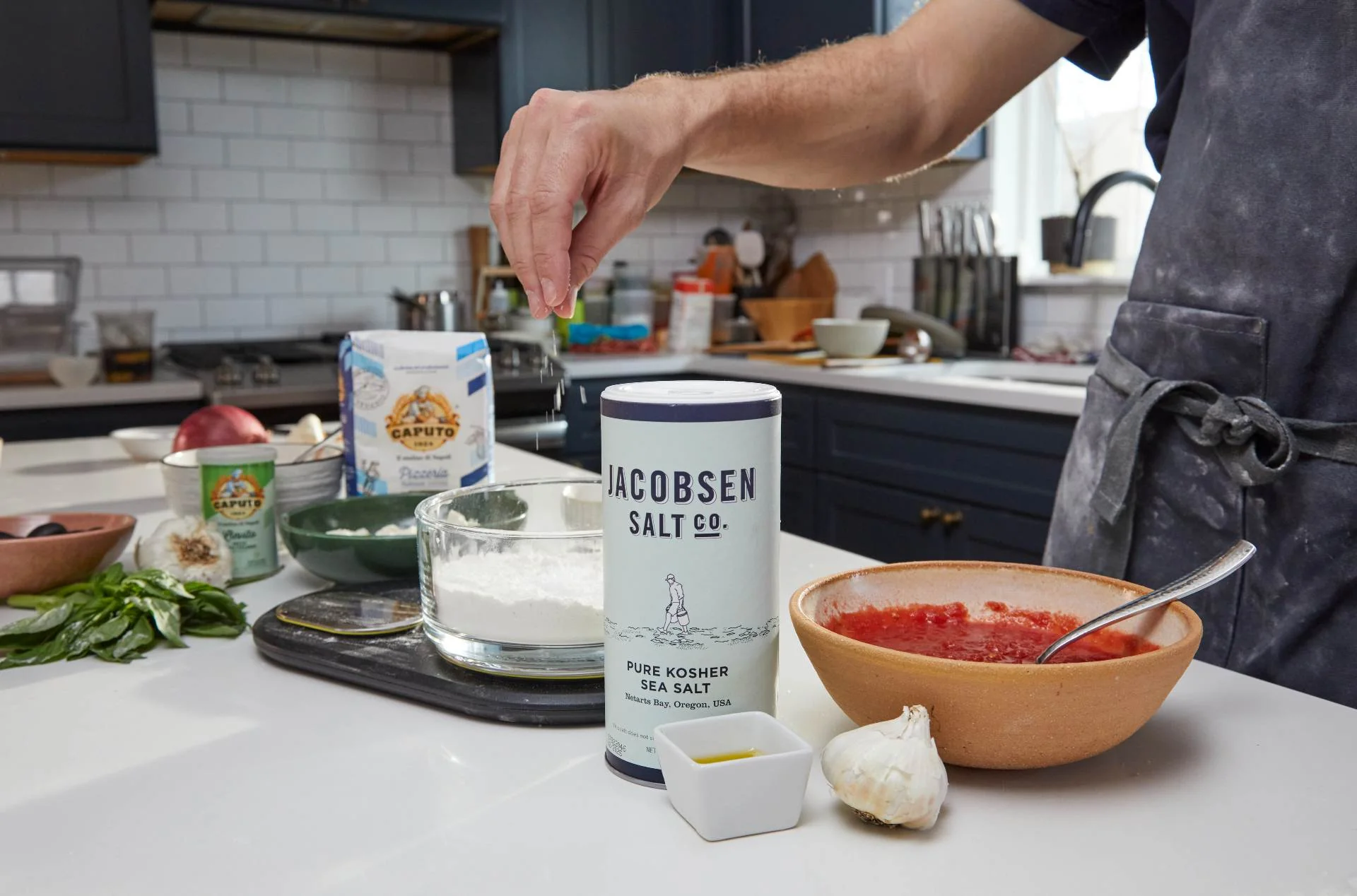 a hand sprinkles salt into a bowl