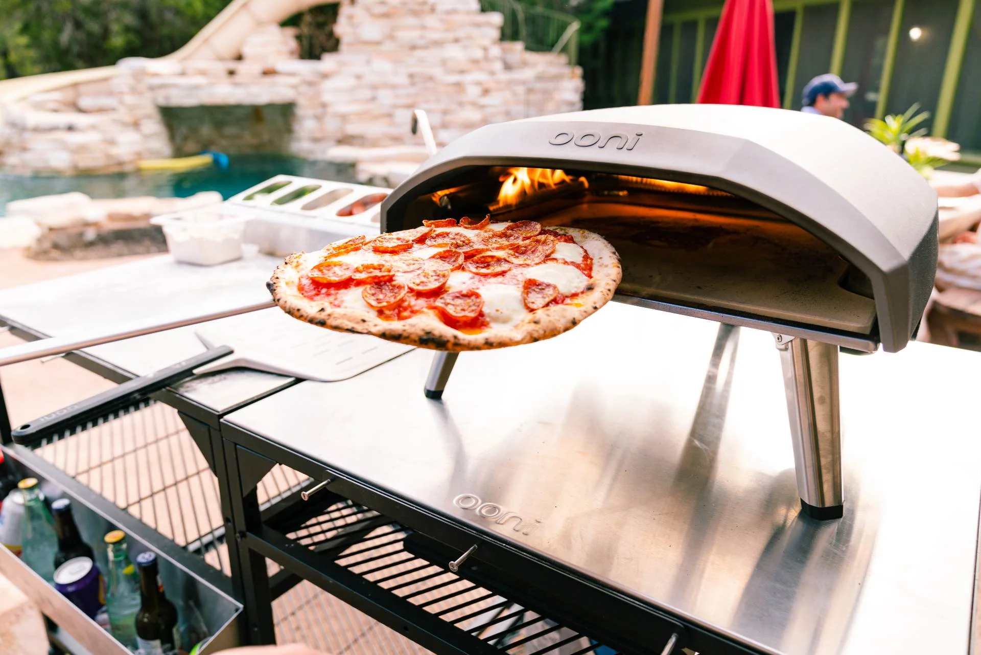 A turning pizza peel being used to turn a pizza in an ooni pizza oven