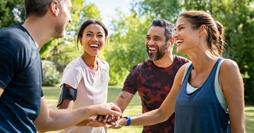 Three youthful and active adults smiling while outdoors