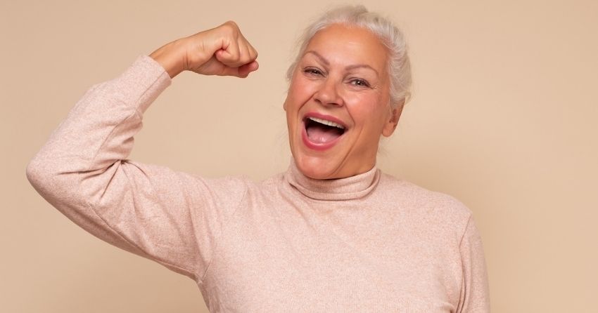 older woman flexing biceps; The Truth About Protein, Part 3: How Much Do Adults Really Need, and Where Should It Come From?