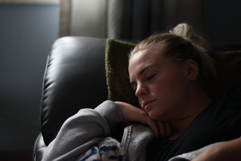 Woman napping on a leather couch