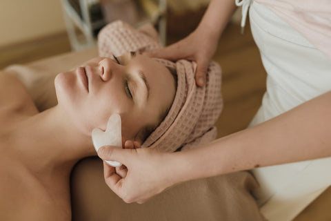 Woman having a facial with a gua sha tool