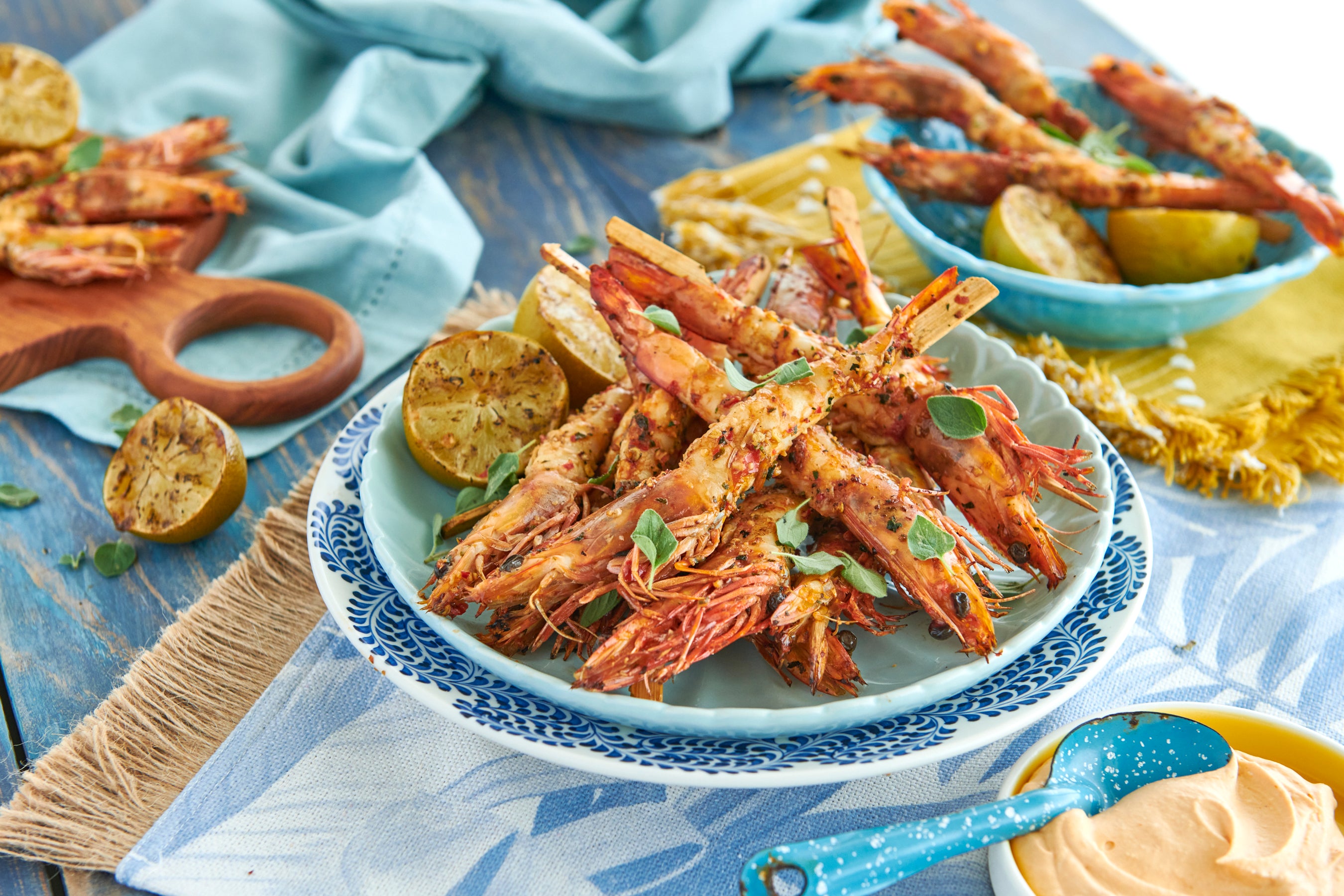 Grilled chilli prawns in a blue dish in the centre of the image.