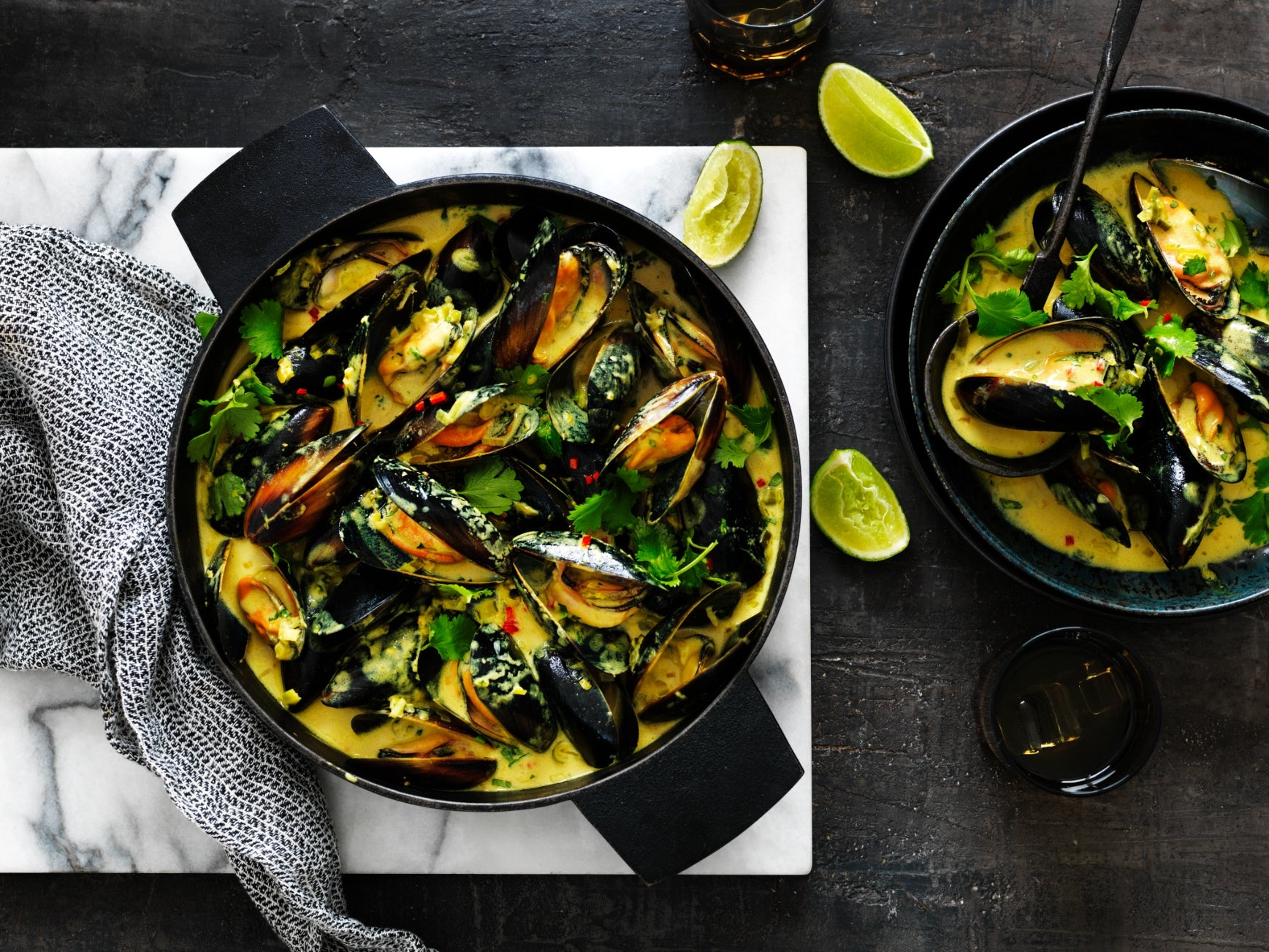 Spicy lemongrass and coconut Thai-style mussels in a black cast iron pot