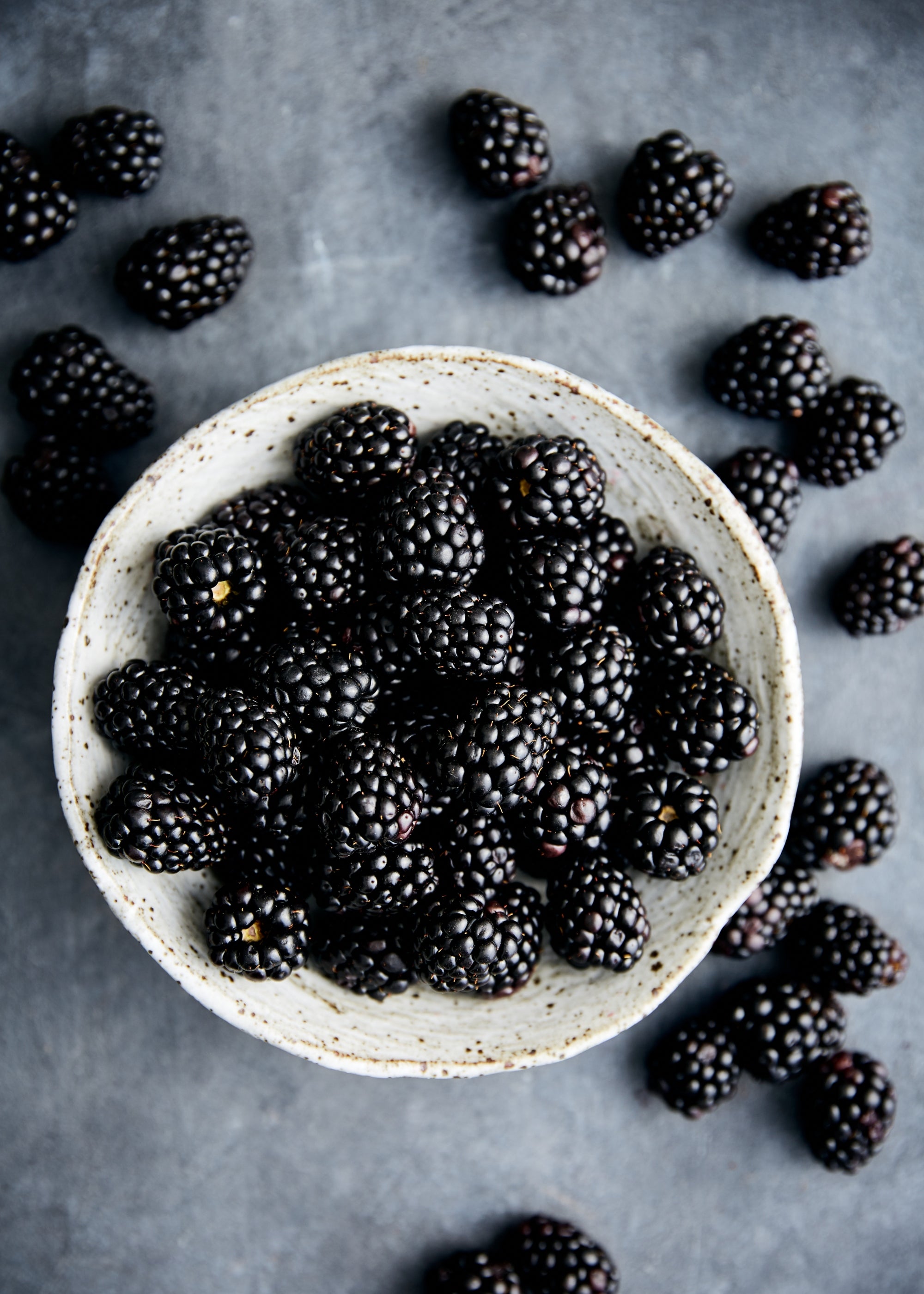 A sack of blackberries on a green wood background