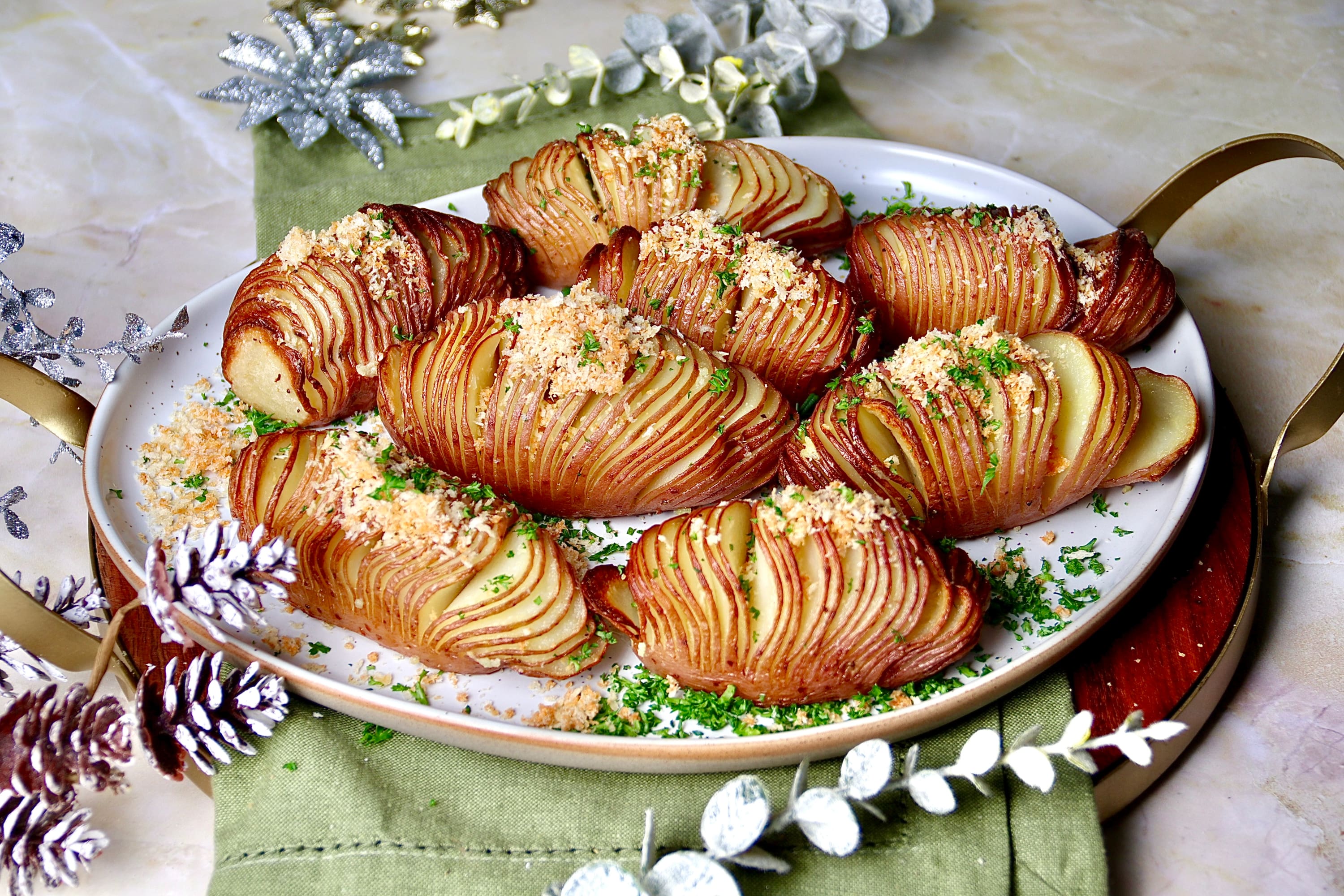 Hasselback potatoes garnished with parmesan crumbs and parsley