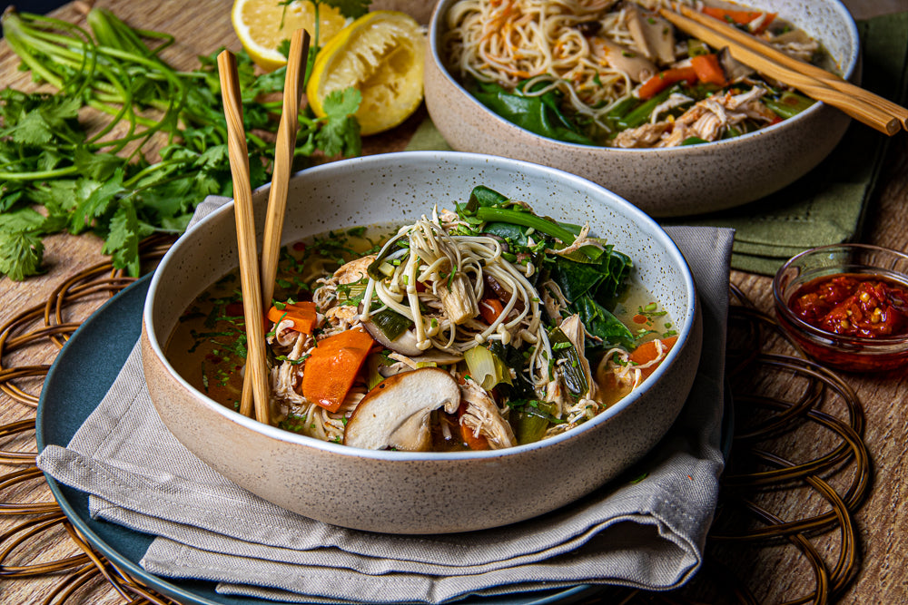 Chicken Noodle soup with mushrooms, gai lan, carrots and shallots.