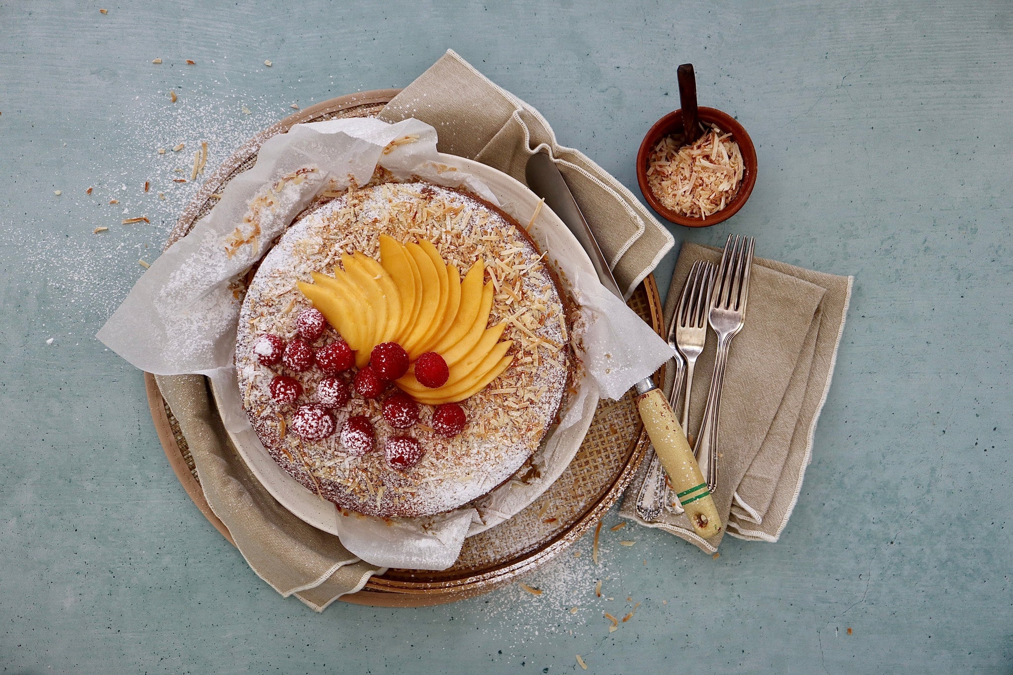 A sponge cake with mango, desiccated coconut and raspberries