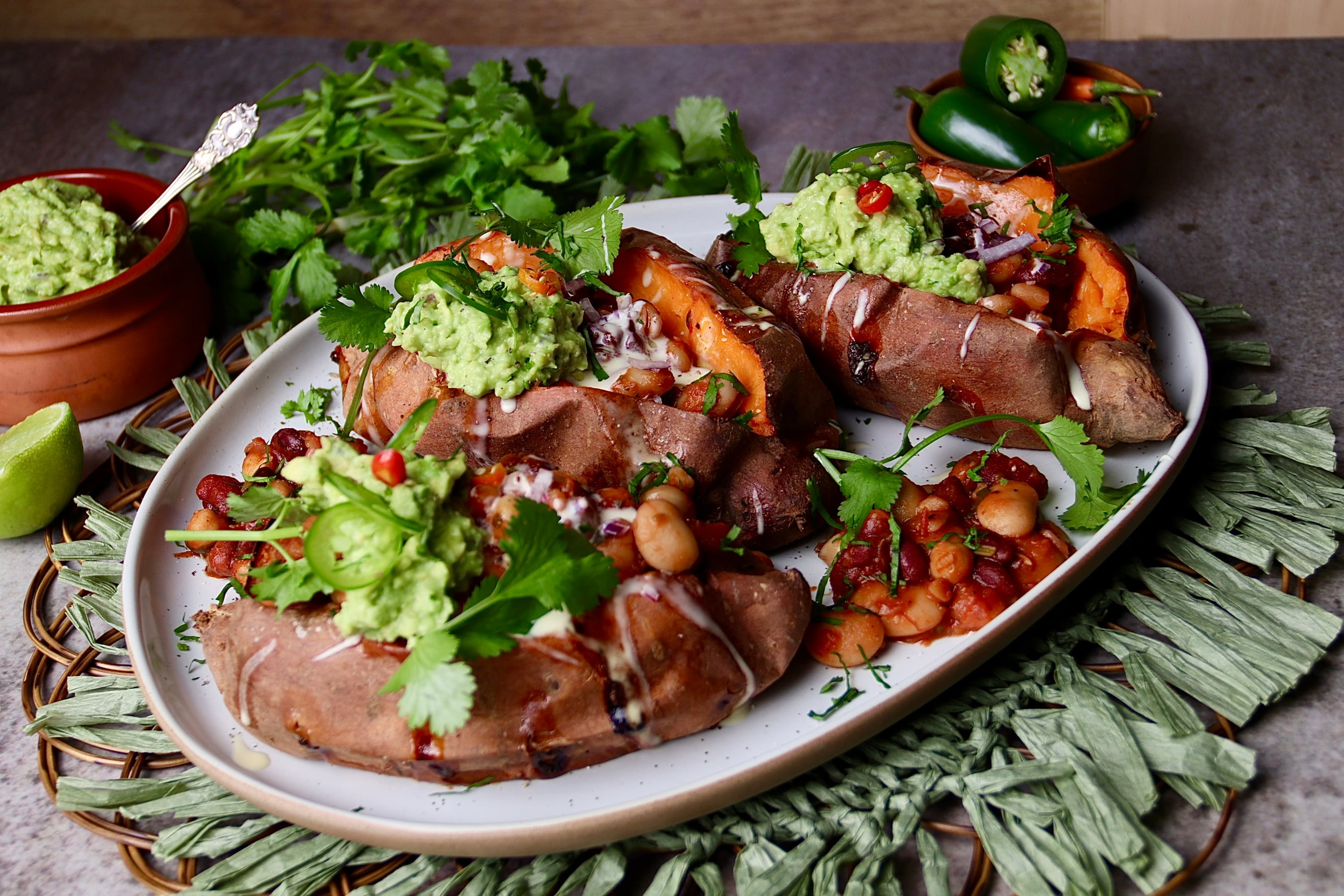 Roast sweet potatoes filled with smoky bean salsa, guacamole and sour cream