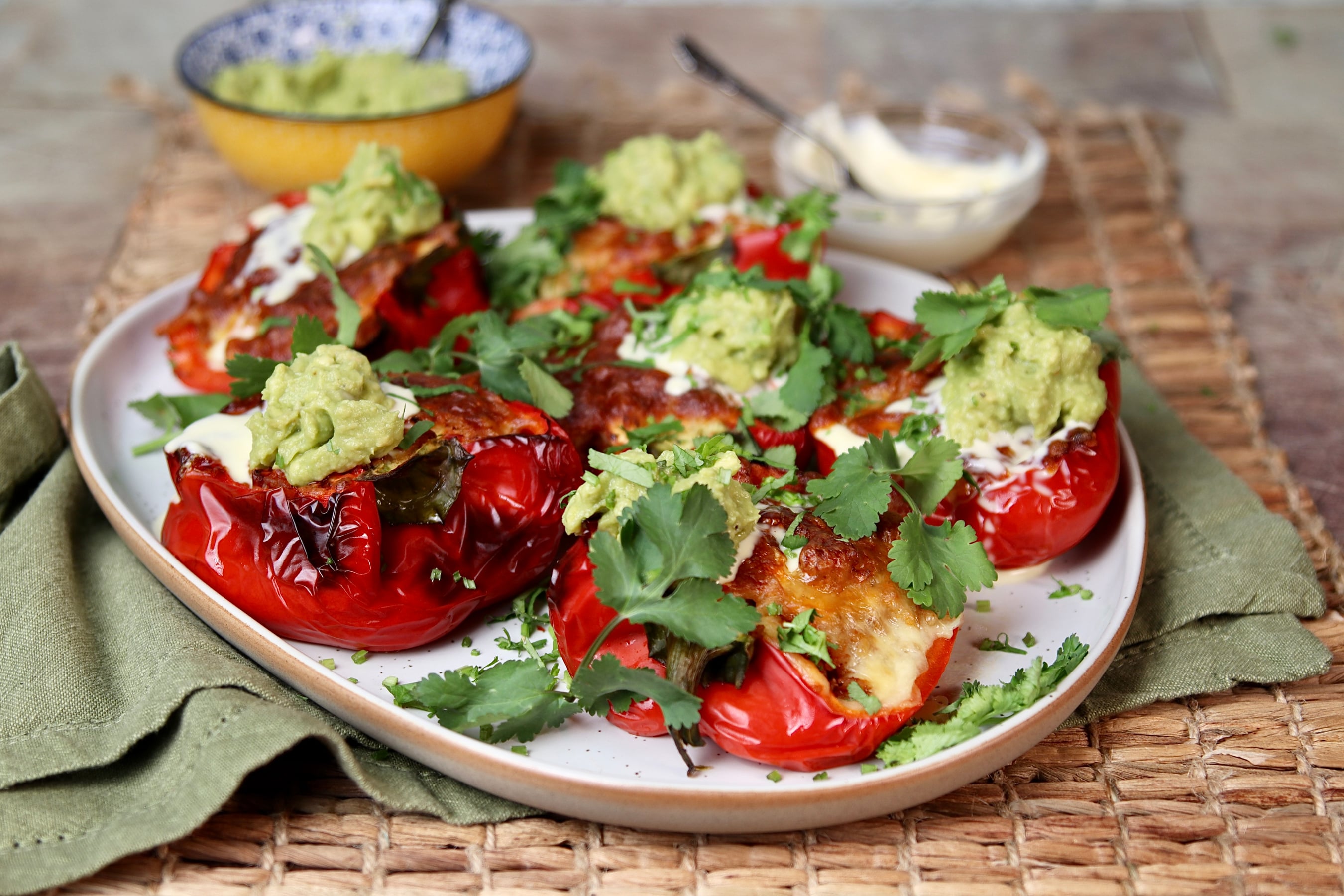 Mexican Style stuffed red capsicums topped with guacamole and sour cream